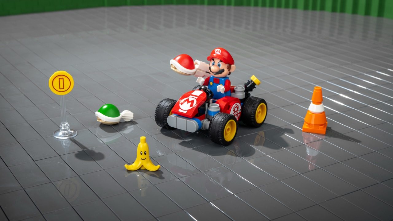 LEGO Super Mario kart set with Mario minifigure, red kart, Banana peel, Koopa shell, coin marker, and traffic cone on gray…