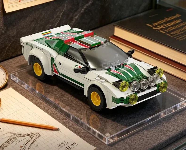 CaDA Lancia Stratos HF rally car model with white body, green stripes, yellow wheels, and roof-mounted lights on display.