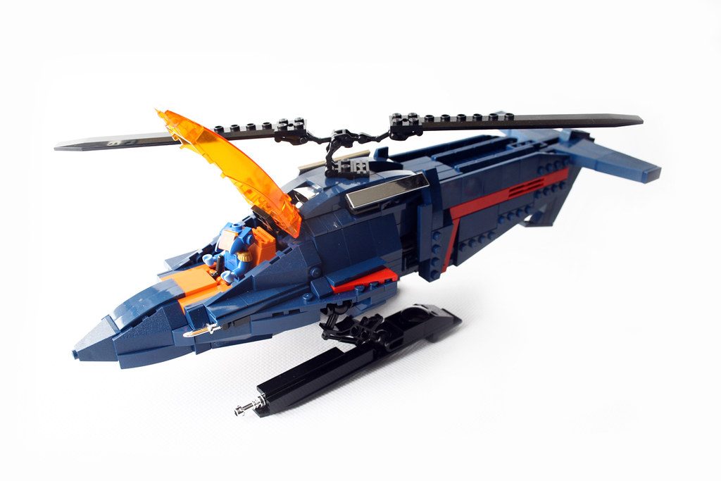 LEGO M.A.S.K. MOC jet vehicle with blue fuselage, red stripe, orange canopy, and rotating weapon turret.