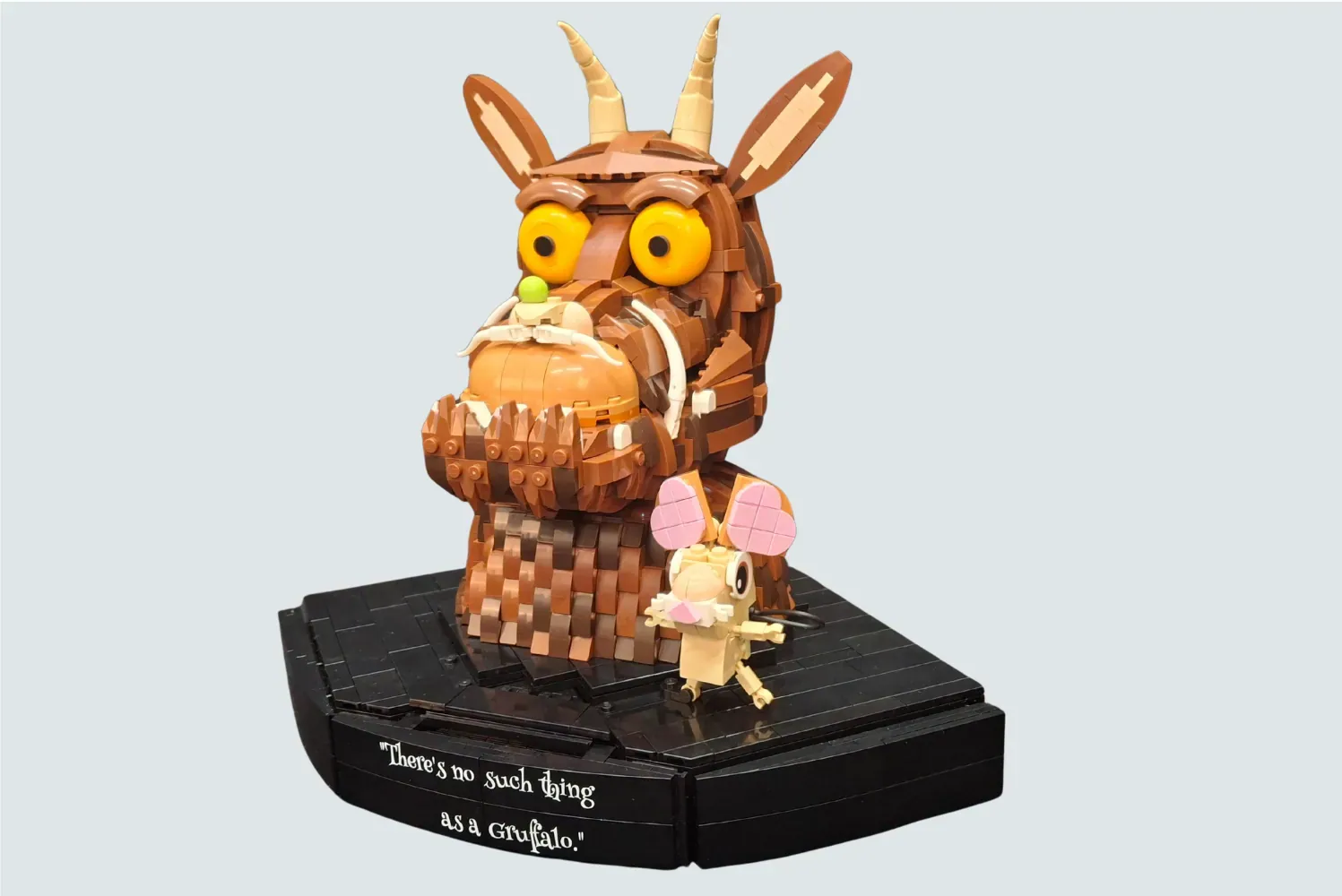 LEGO Gruffalo and Mouse set with brown creature holding child figure on black base displaying quote.