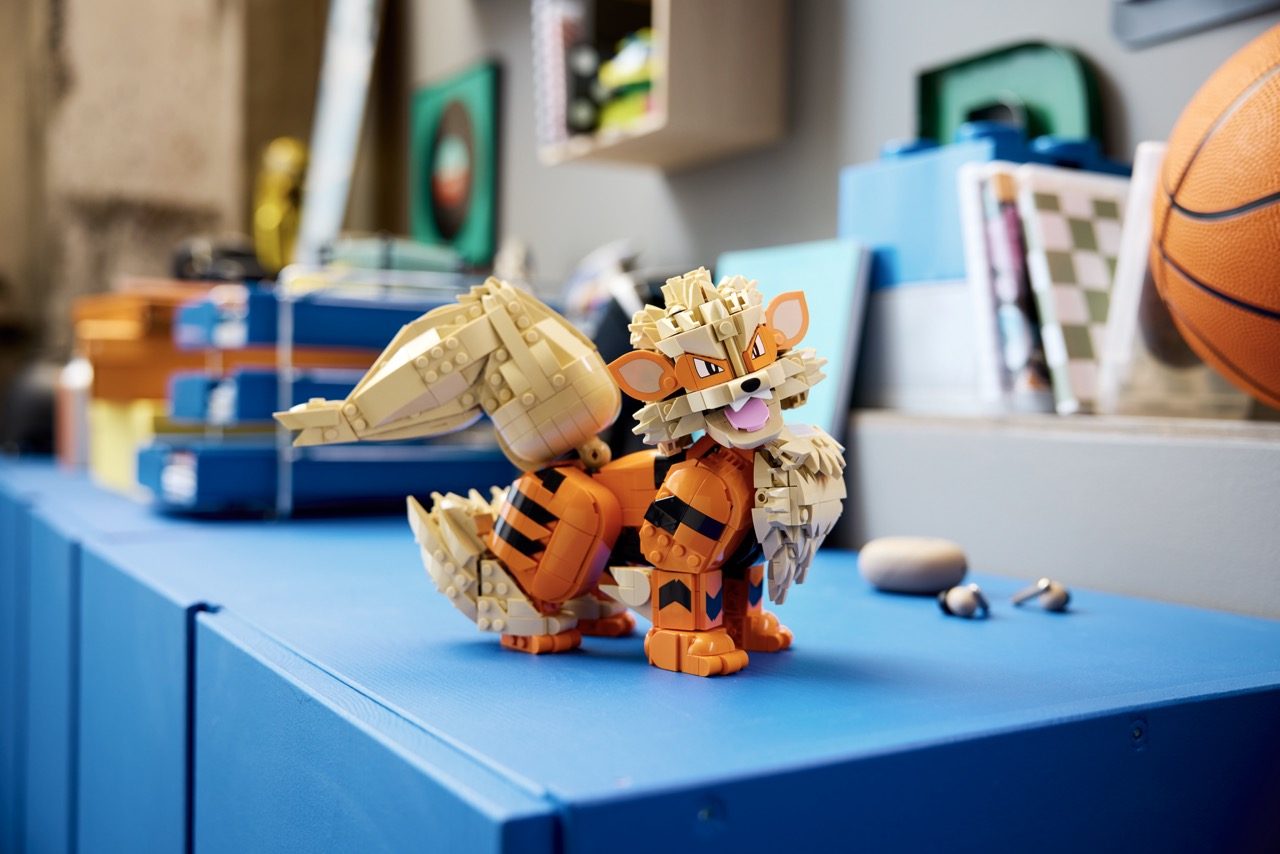 LEGO Pokémon Charizard set displayed on blue platform with basketball and room décor in background.