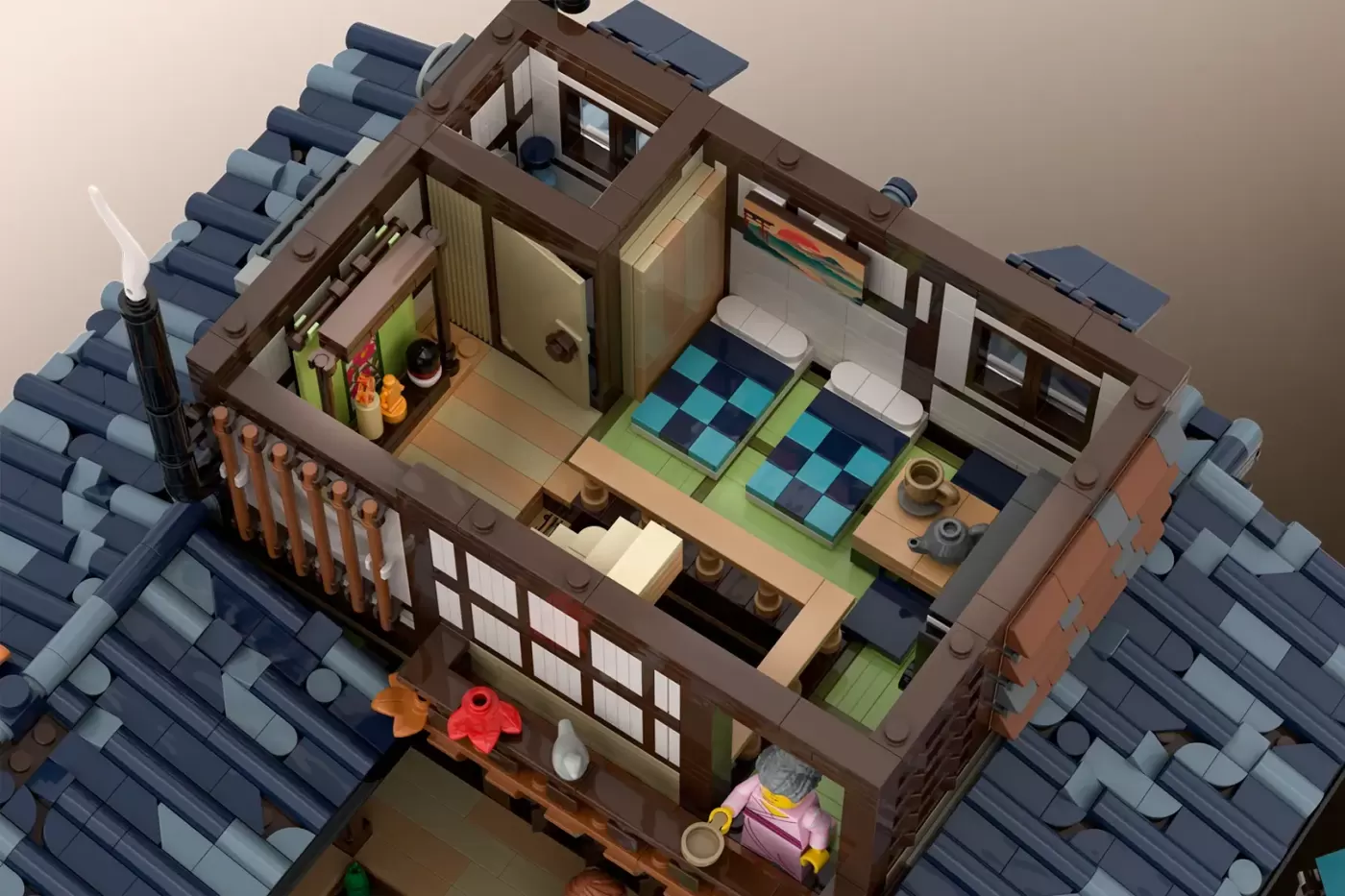 LEGO Japanese onsen building with open roof showing interior rooms, furniture, minifigures, and autumn details on tiled ro…
