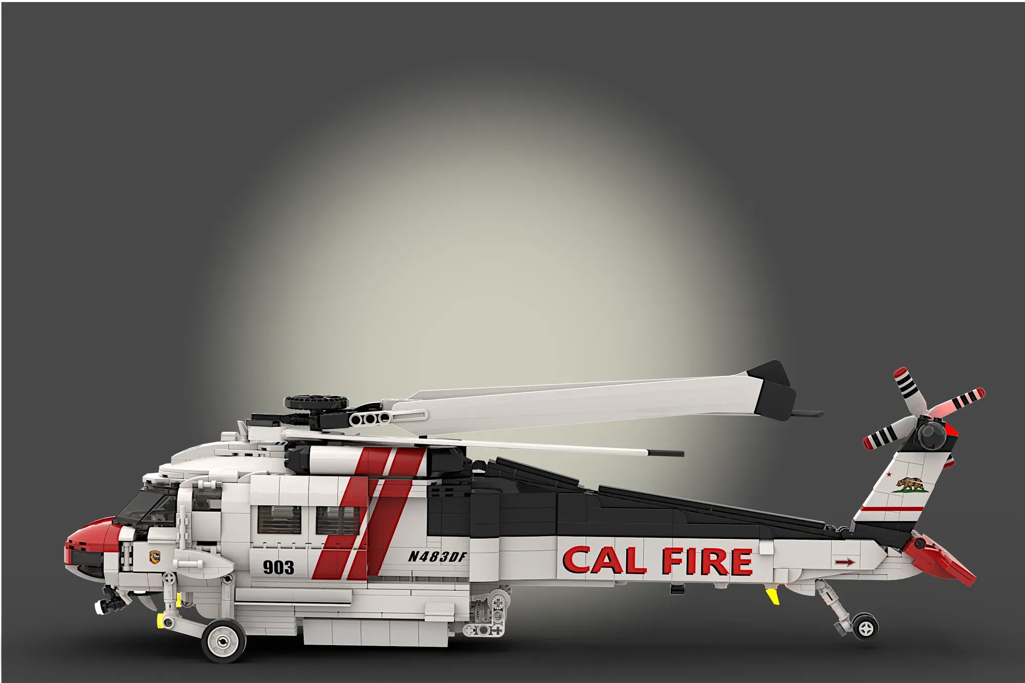 LEGO Firehawk helicopter model 903 with red and white CAL FIRE livery and rotating blades against gray background.