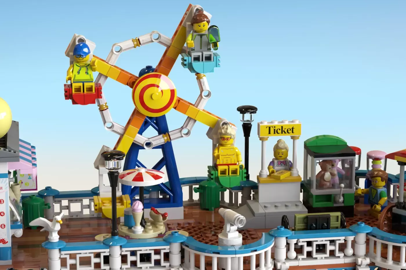 LEGO Victorian seaside pier with ferris wheel, ticket booth, and minifigures enjoying the amusement park scenery.