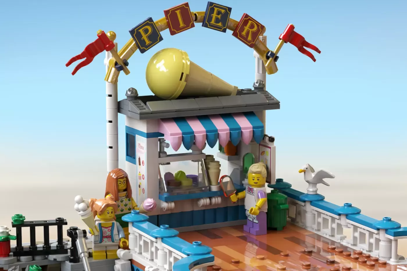LEGO Victorian pier set with ice cream stand, minifigures, and yellow cannon with "PIER" sign overhead.