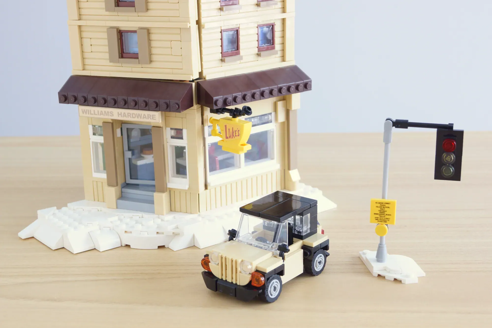 LEGO Stars Hollow set featuring Luke's Diner, cream-colored buildings, jeep vehicle, traffic light, and street accessories.