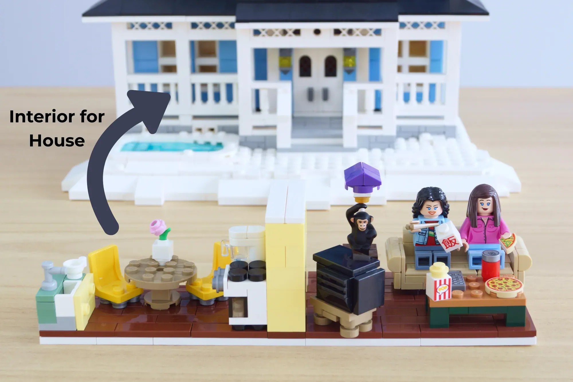 LEGO Gilmore Girls set showing Luke's Diner interior with minifigures, furniture, food items, and the iconic house exterio…