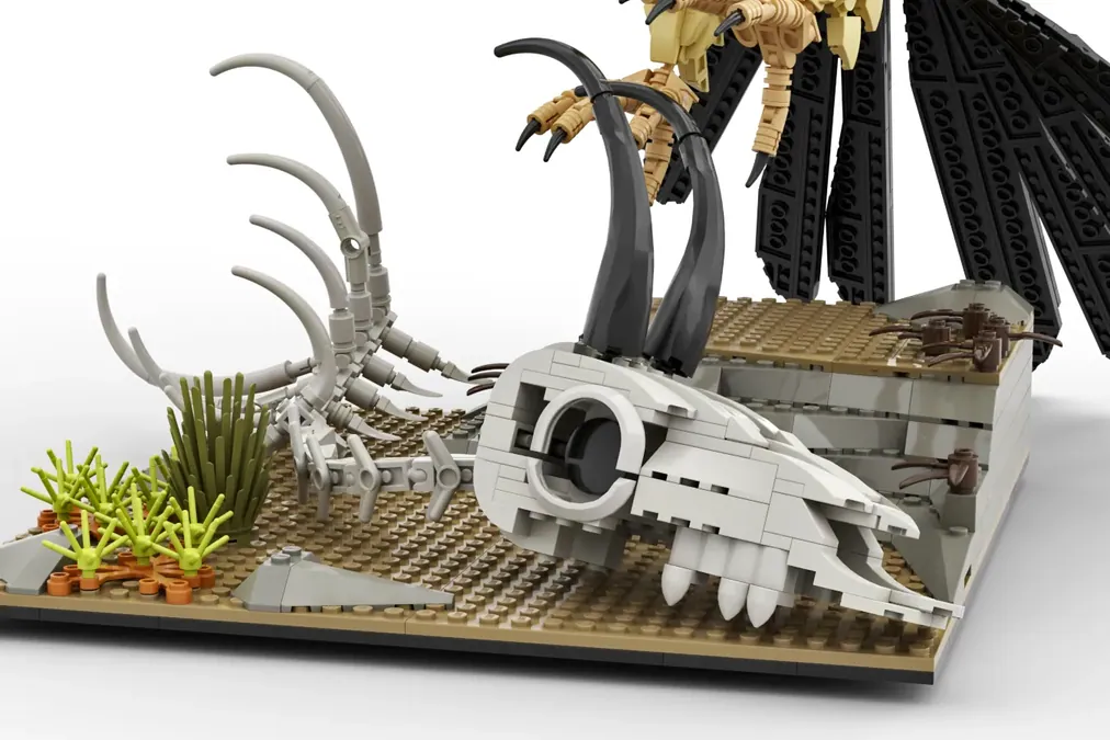 LEGO Ideas Bearded Vulture set with white skull, black wings, tan minifigure, and desert base with plants.