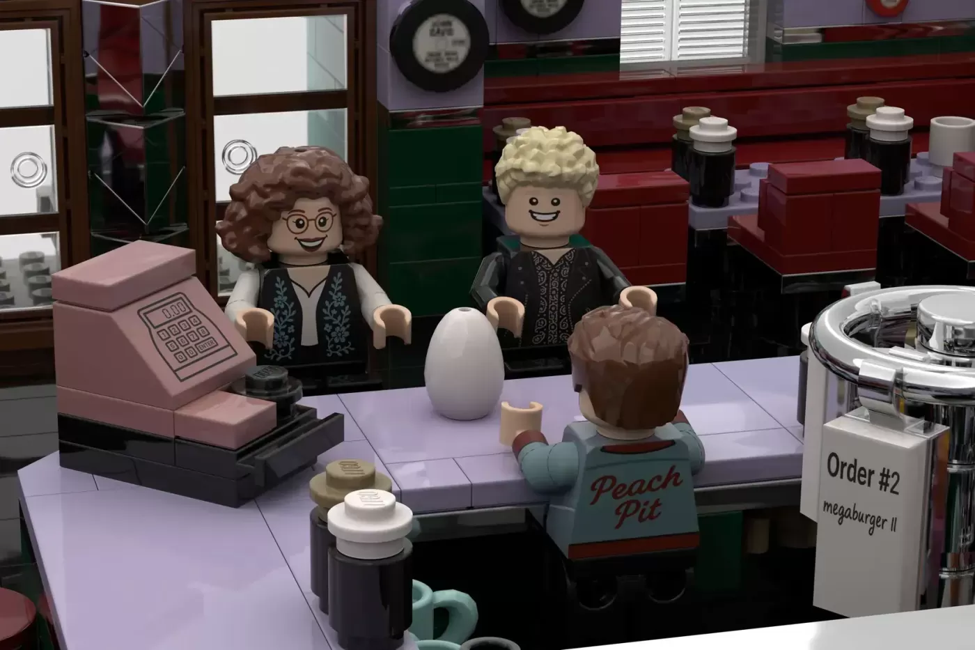 LEGO Peach Pit diner set with minifigures at counter, cash register, and order display visible.
