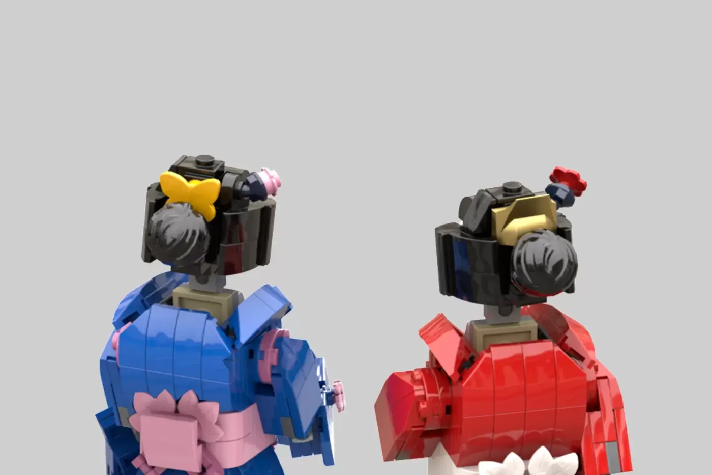 Two LEGO figures in kimono dresses: one in blue with pink bow, one in red with red flower accessory, shown from behind.