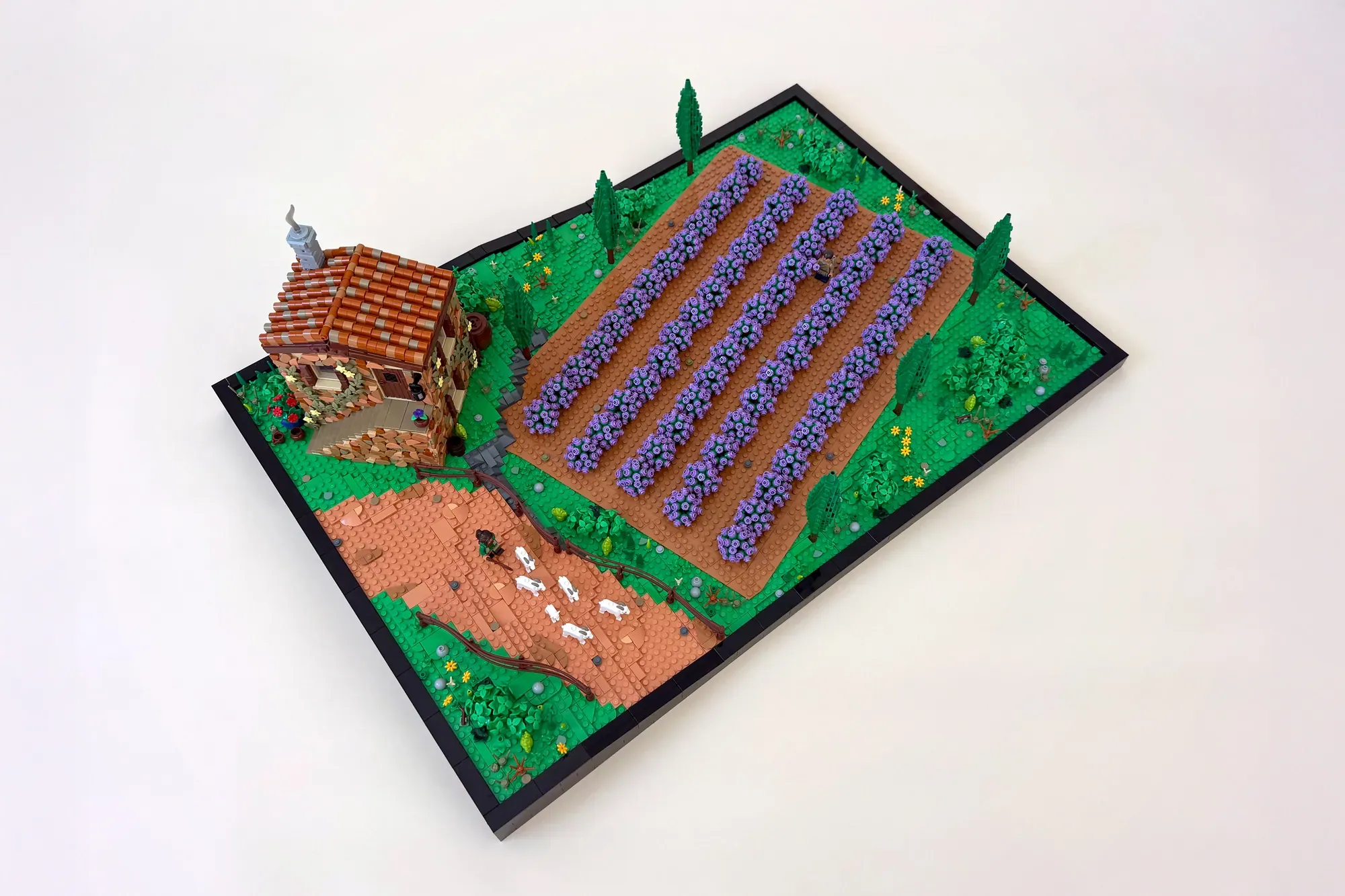 LEGO lavender field diorama with brick farmhouse, rows of purple flowers, grazing sheep, and decorative landscaping.