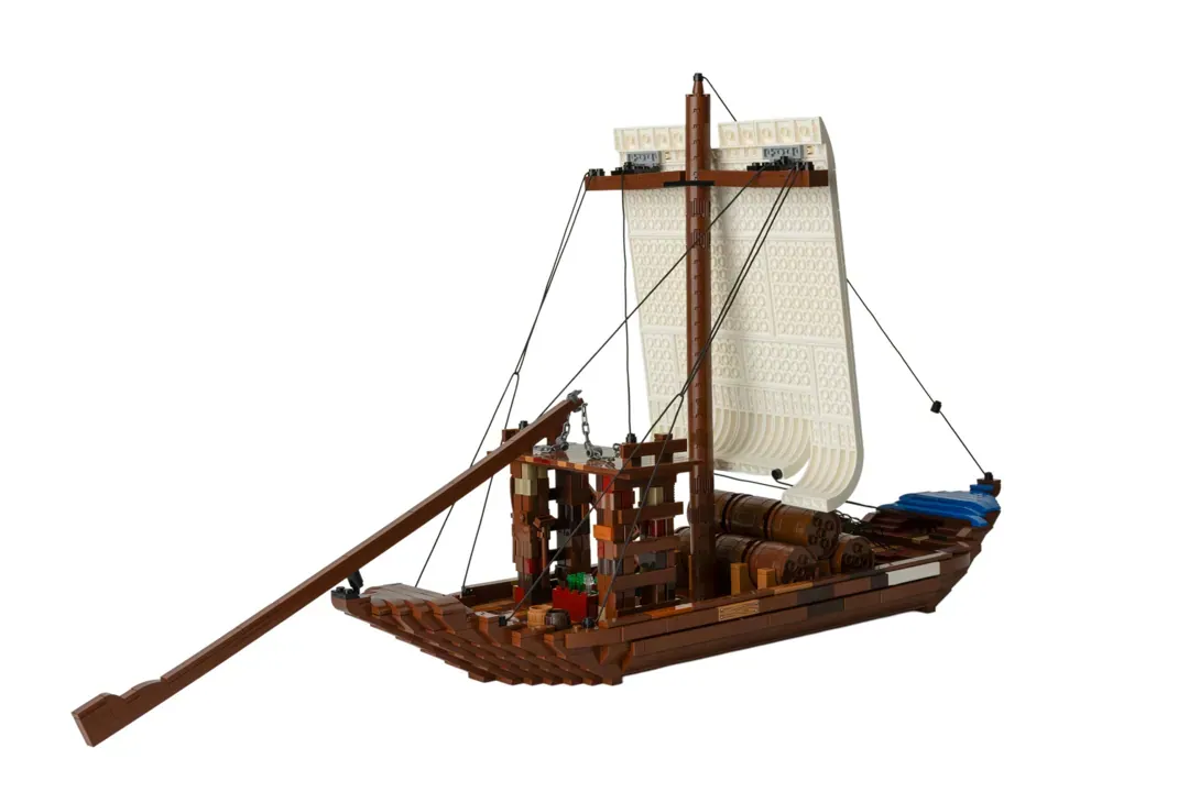 LEGO Barco Rabelo model featuring brown wooden hull, cream fabric sail, central mast, and detailed cargo deck.