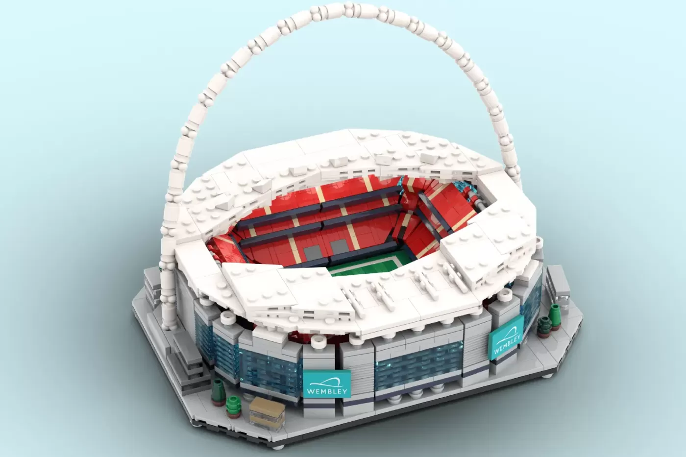 LEGO Wembley Stadium model with iconic white arch, red seating, and turquoise signage on base.