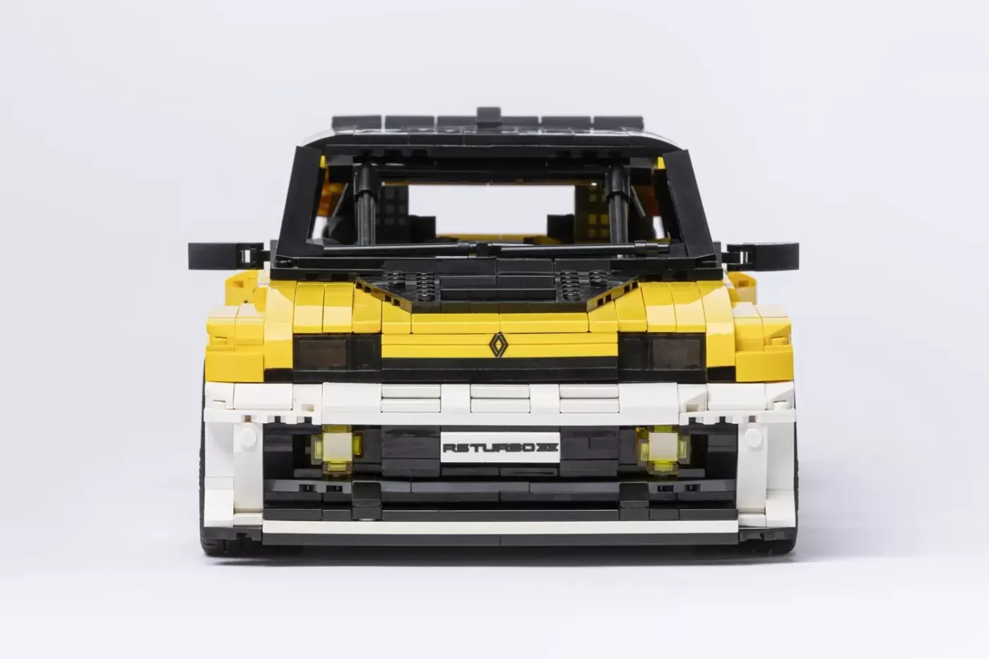 LEGO Renault 5 Turbo 3E model in yellow and white, front view showing detailed grille and headlights.