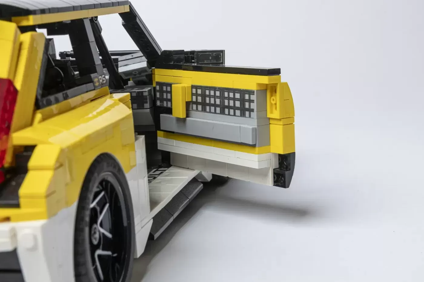 LEGO Renault 5 Turbo 3E model with yellow and white color scheme, showing open door and detailed interior design.