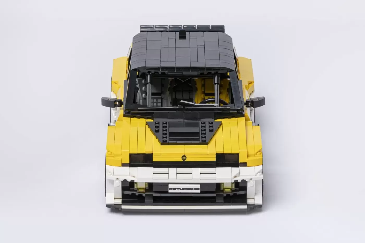 LEGO Renault 5 Turbo 3E model in yellow and white, top-down view showing detailed interior and roof rack.