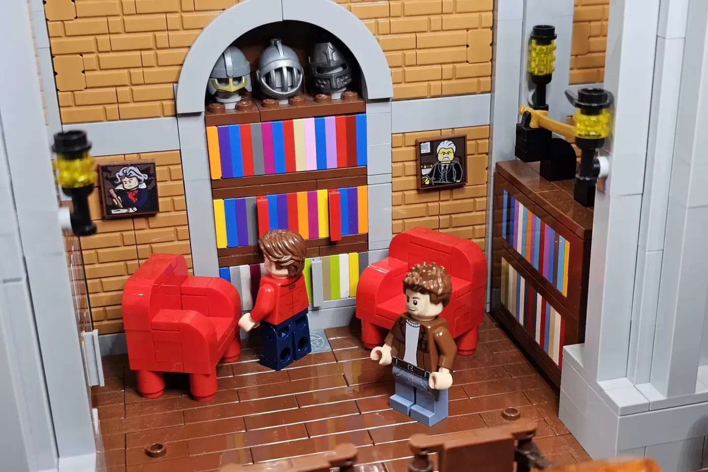 LEGO bunker interior with red chairs, two minifigures, colorful striped walls, arched doorway, and knight helmets on display.