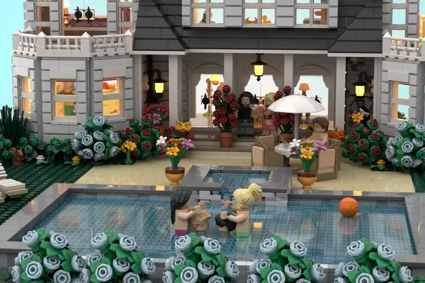 LEGO recreation of a luxurious beachfront mansion with pool, minifigures, flowering gardens, and elegant architectural det…