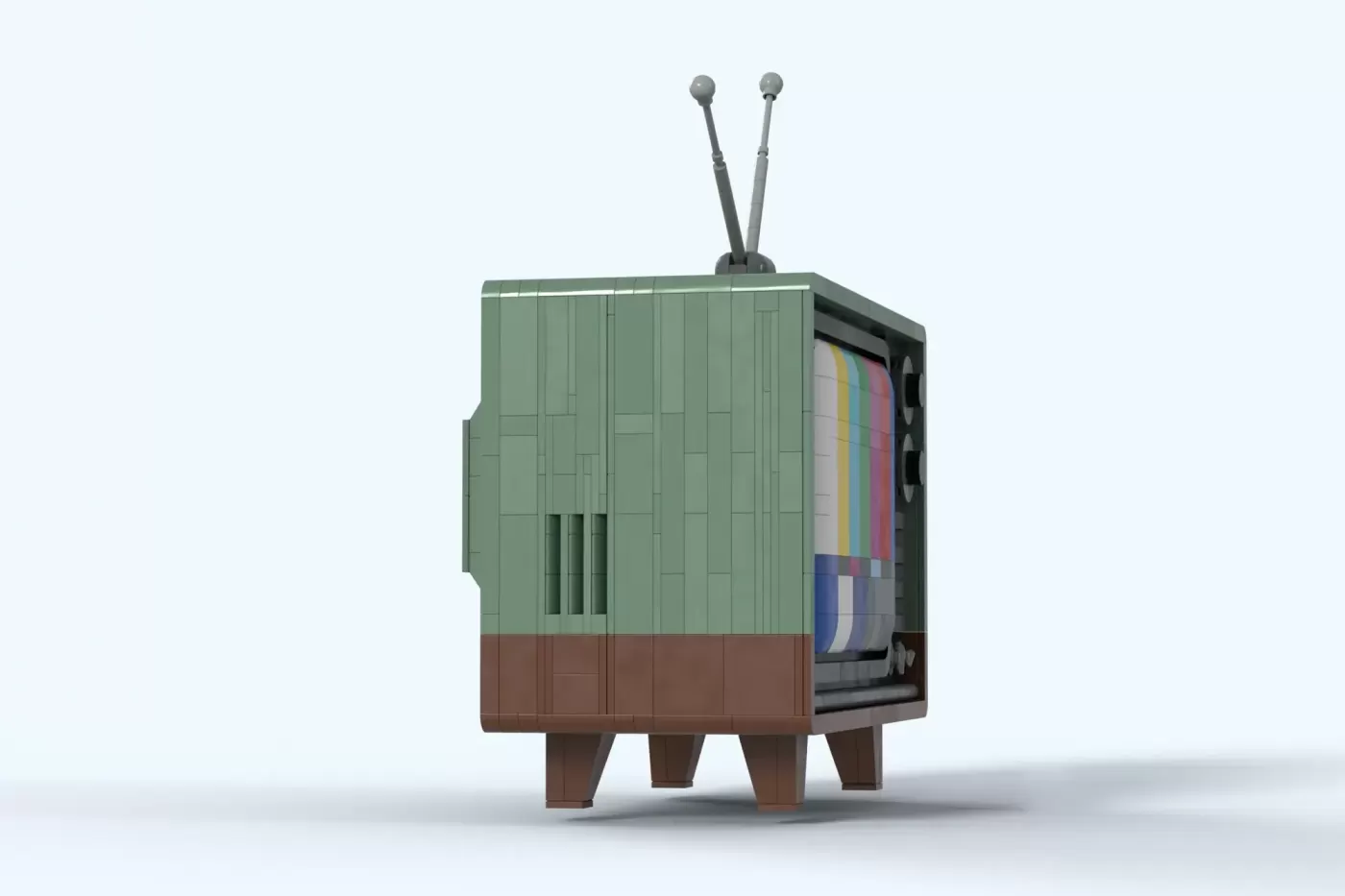 LEGO classic TV set with green and brown body, rabbit ear antennas, and colorful test pattern screen visible inside.