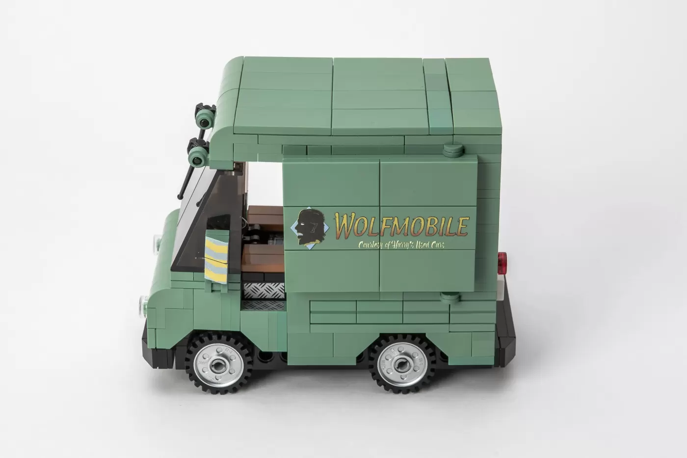 Green LEGO Wolfmobile brick model with "Wolfmobile" text and wolf profile logo on side.
